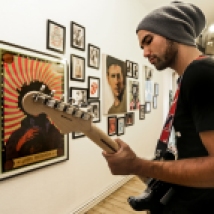 Ein Leben für die Musik: Rockstars an der Wand, Gitarre in der Hand. So wohnt Sänger Cyril Krueger. Foto: Ina Richter
